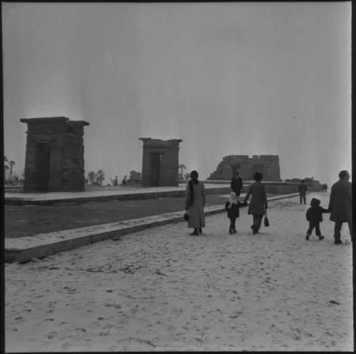 El Templo de Debod nevado. Siete personas caminando.